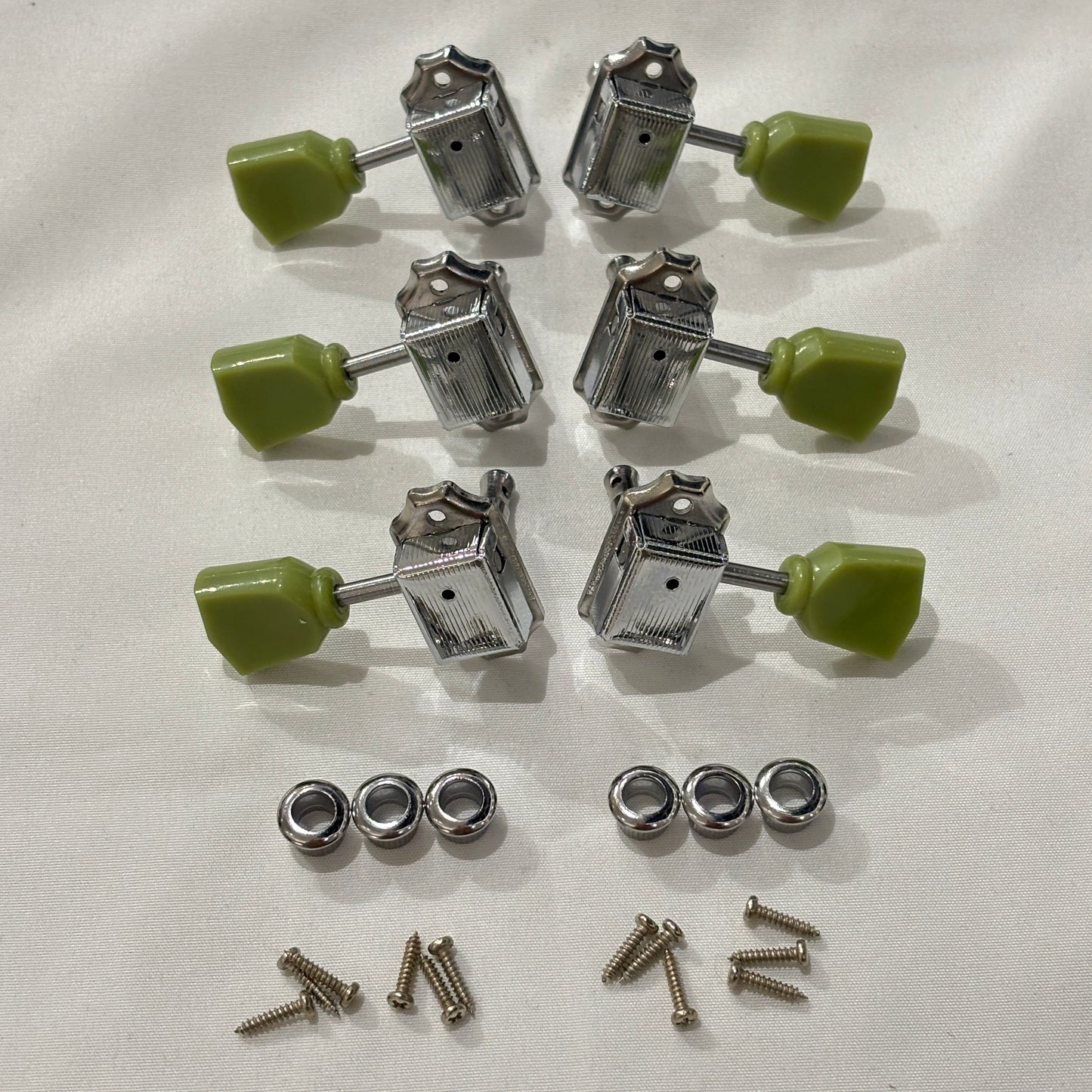 Set of chrome Keystone guitar tuners / machine heads with green buttons on a white background