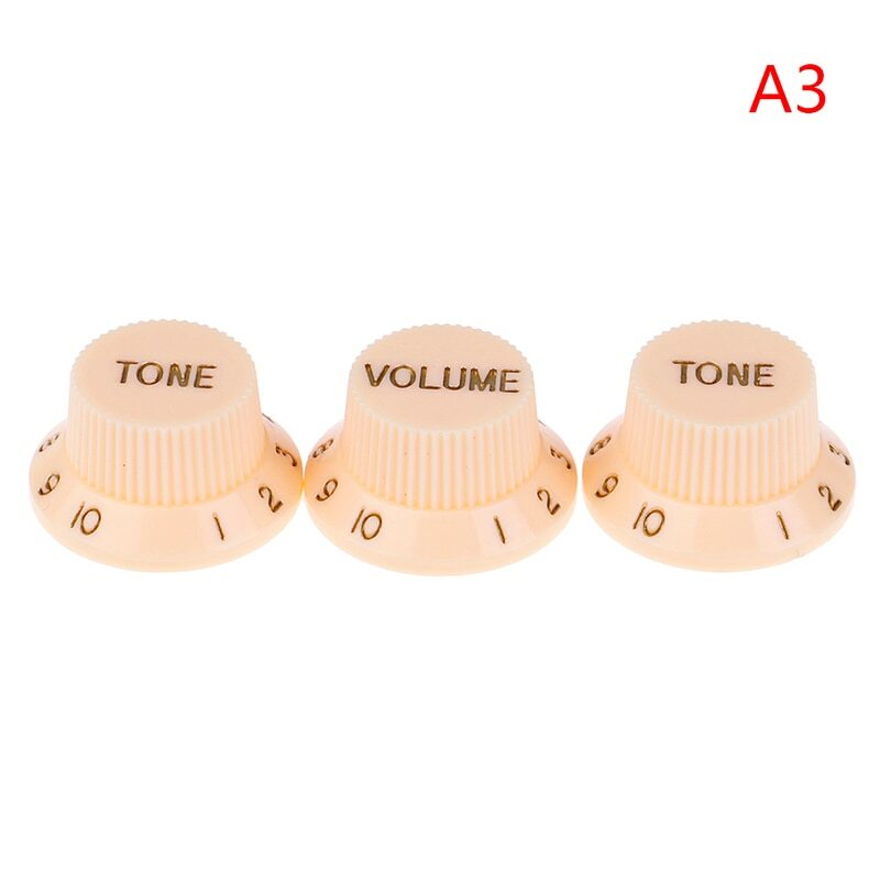 Three Cream electric guitar Control Knobs labeled 'TONE' and 'VOLUME' , ST-style, in Gold text on a white background.