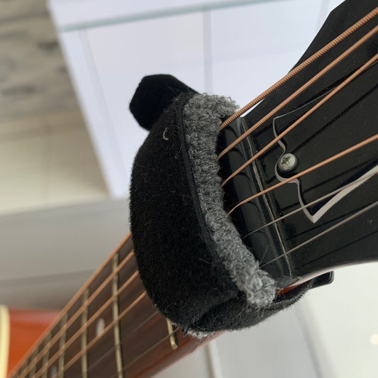 Close-up of a Guitar String Muter/Damper photographed on a guitar neck from above.