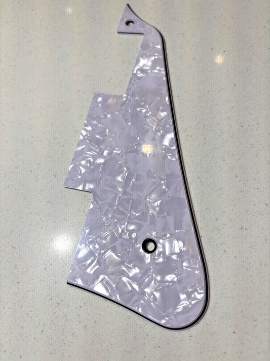 Electric Guitar pick guard in Pearl White on a light white surface.