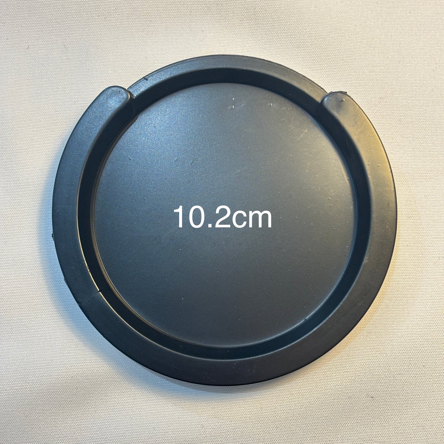 A large acoustic guitar Feedback Buster / Suppressor  on a light grey surface.