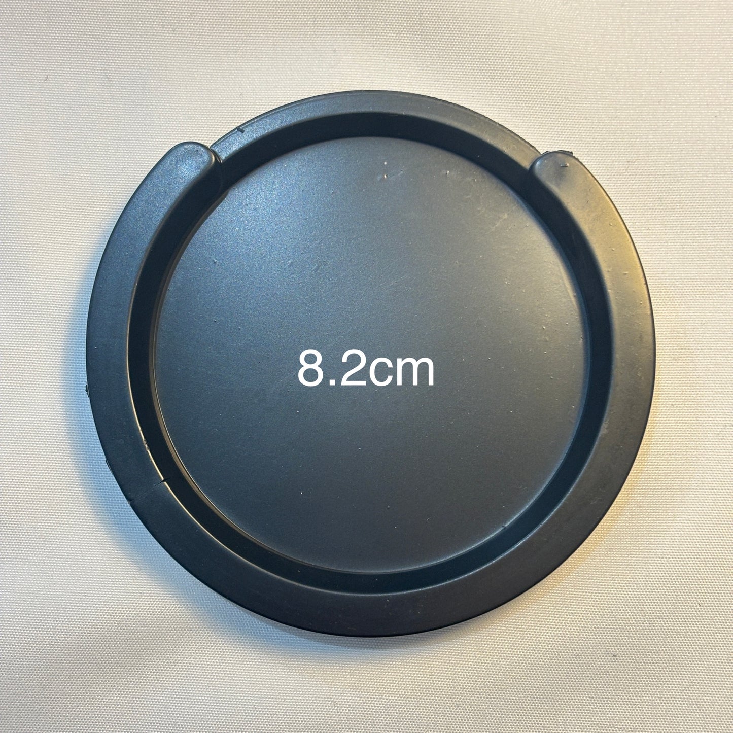 A small acoustic guitar Feedback Buster / Suppressor  on a light grey surface.