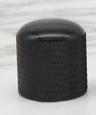 Black electric guitar control knob on a white background.