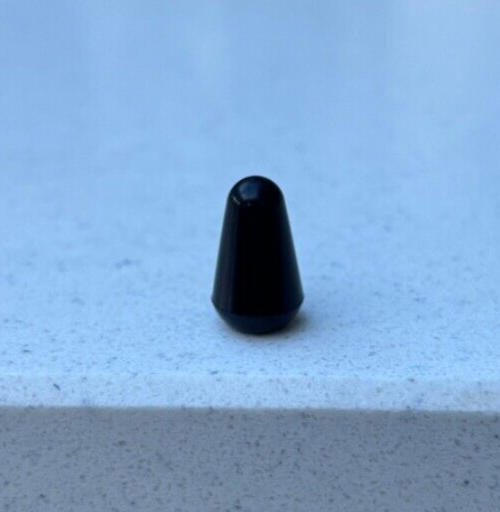 Black electric guitar Toggle Switch Tip on a Grey background.
