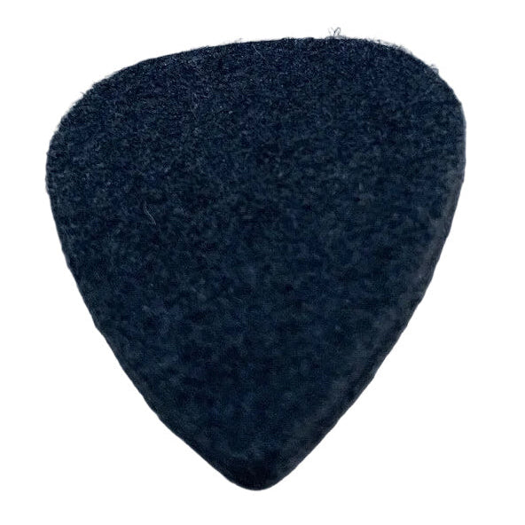 Black felt guitar pick ('plectrum') on a textured grey surface,
