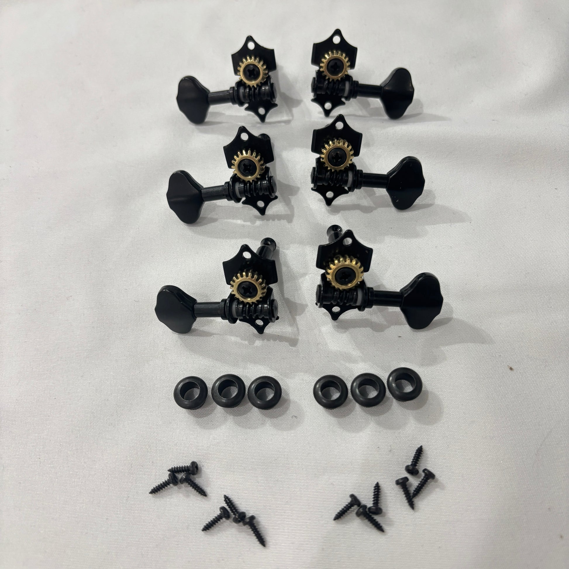 Set of black open back vintage acoustic guitar machine heads and fixings on a white background