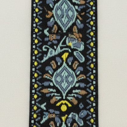 Close up of a Blue, Yellow and Black Embroidered Guitar Strap pattern on a white background.