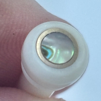 Bone acoustic guitar bridge pin with brass and abalone held in a hand