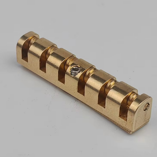 Brass electric guitar roller nut on a white background.