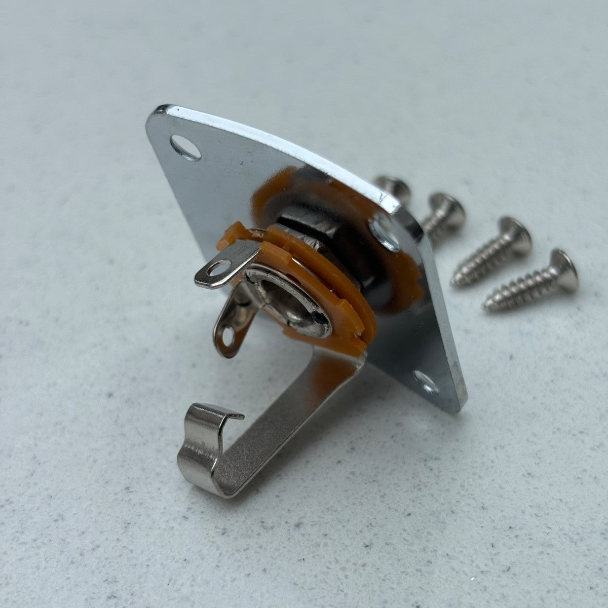 Chrome Electric guitar Jack Plate and Socket LP-style photographed from the side on a light grey background.