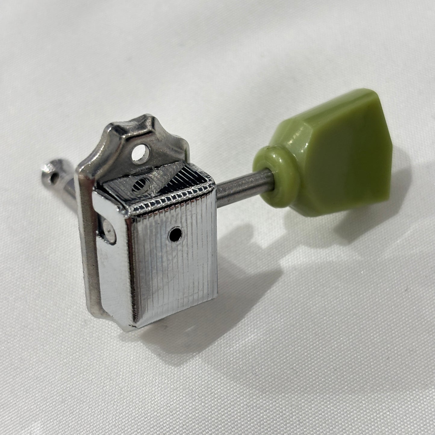Chrome Keystone guitar tuner / machine head with green buttons on a white background