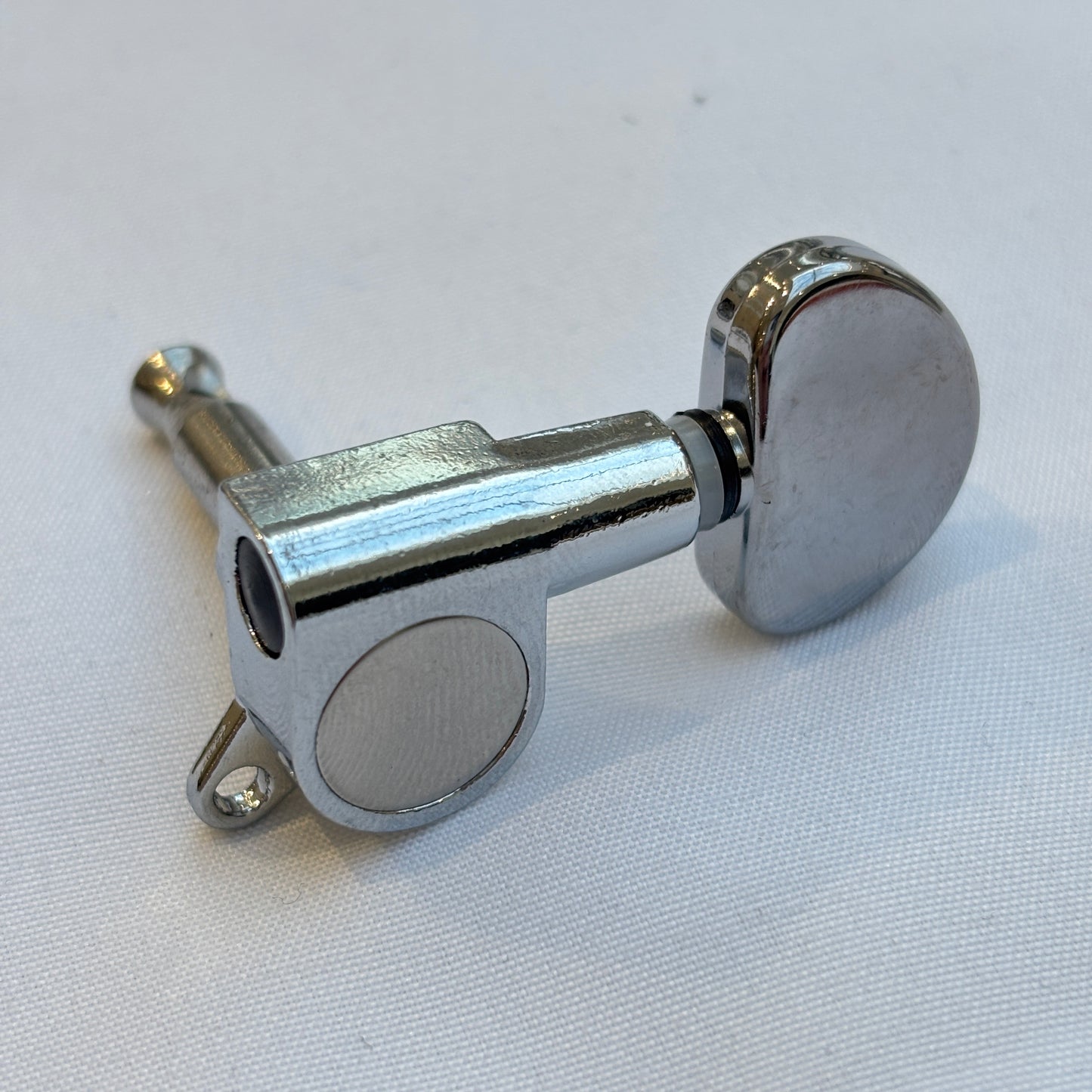 Chrome guitar tuner / machine head with kidney shaped button on a white background