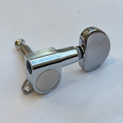 Chrome guitar tuner / machine head with kidney shaped button on a white background