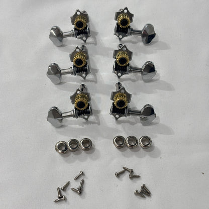 Set of chrome open back vintage acoustic guitar machine heads and fixings on a white background