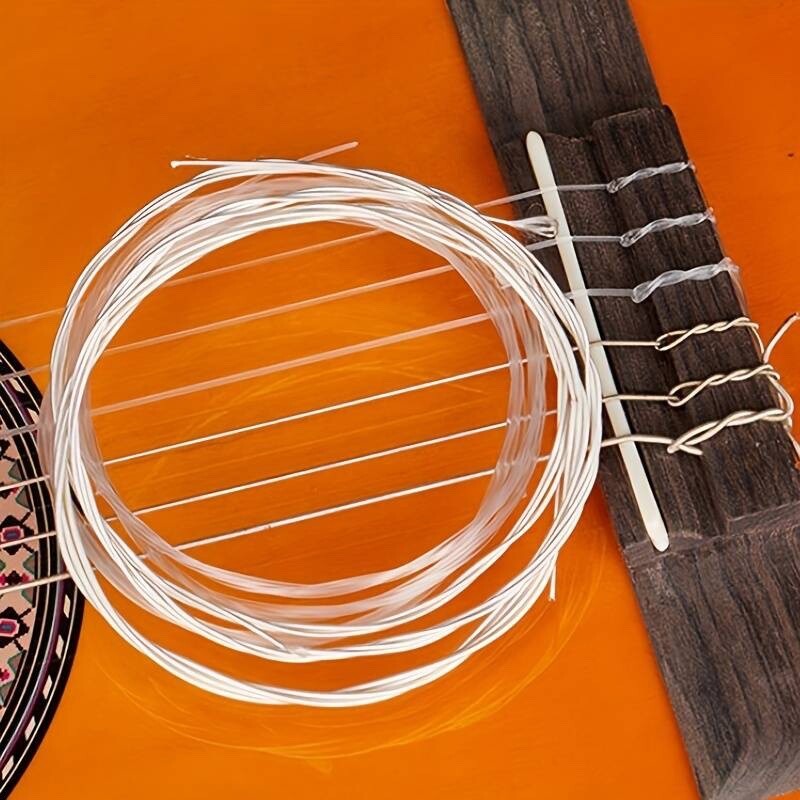 A set of Classical / Spanish Guitar Strings photographed in a coil lying on a guitar.