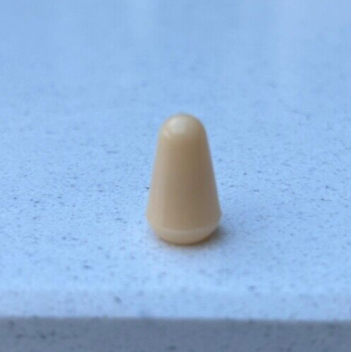 Cream electric guitar Toggle Switch Tip on a Grey background.