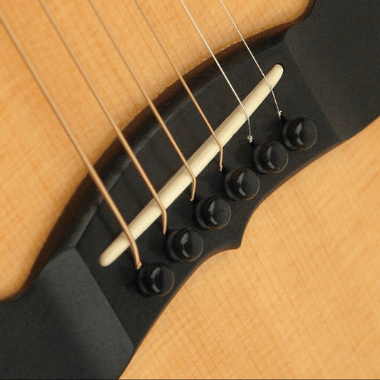 A set of Ebony Guitar Bridge Pins installed in the bridge of an Acoustic Guitar.