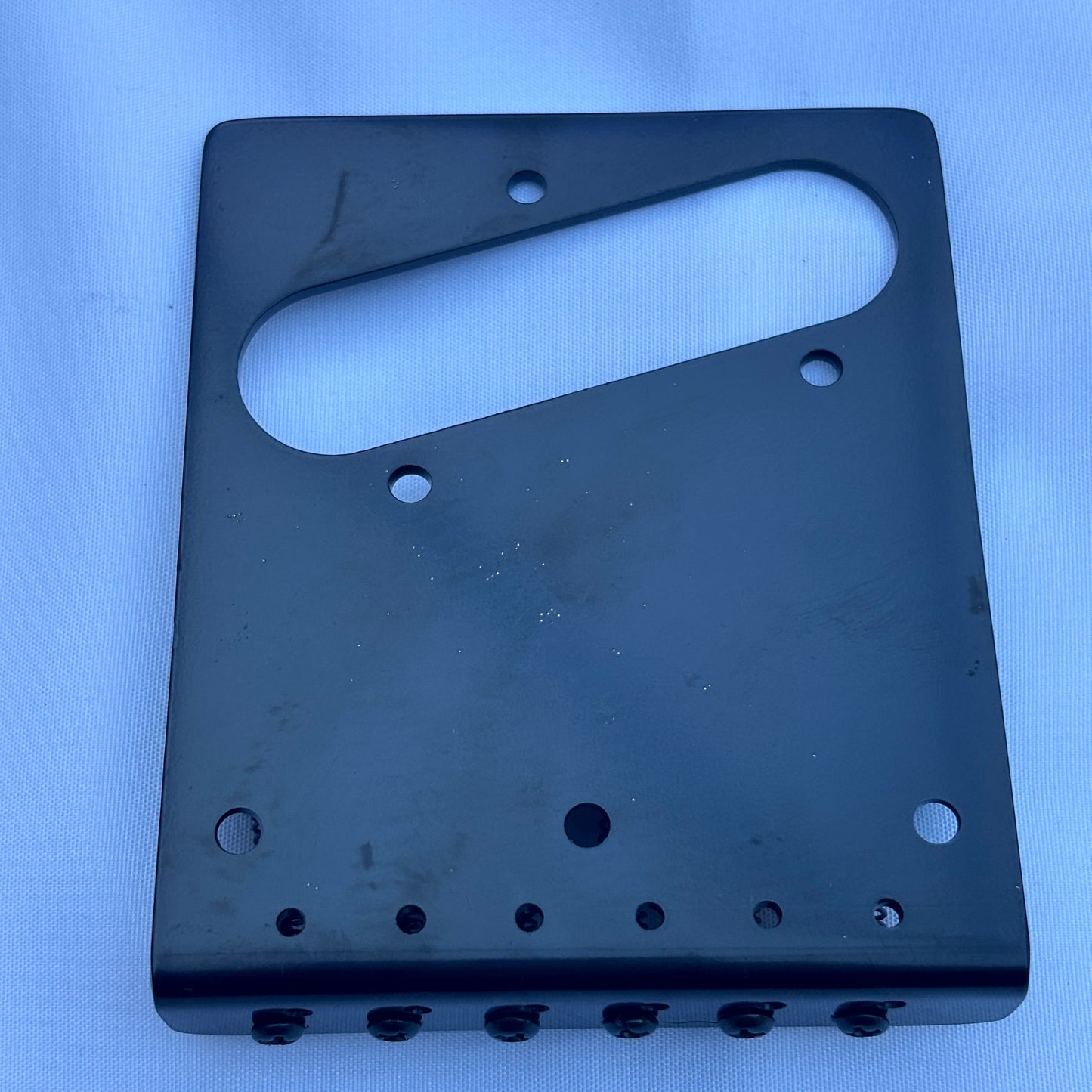 The back of an electric guitar modern guitar bridge in Black on a white background.