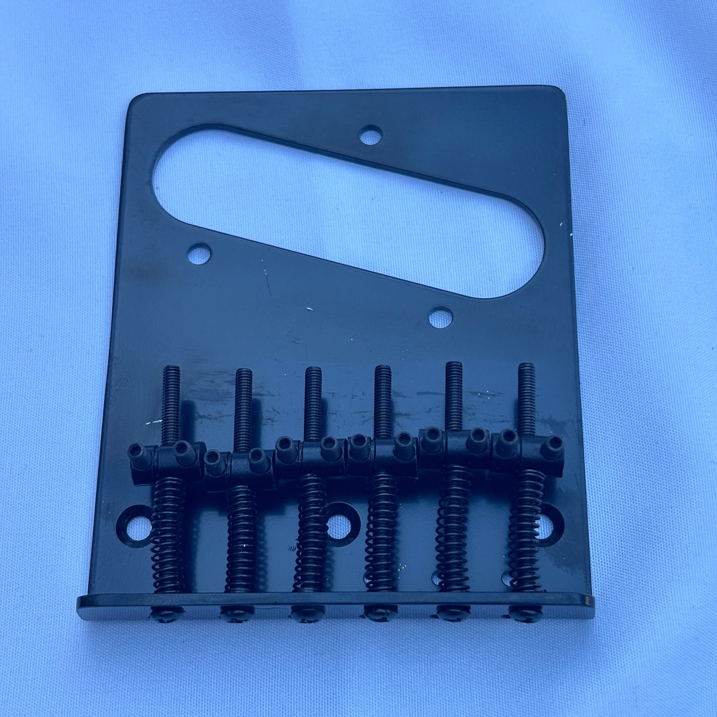 A gold modern electric guitar bridge, TL-style on a white background.