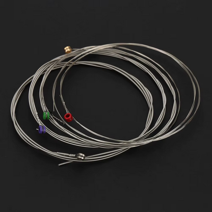 Set of Electric Guitar strings with coloured ends on a black background.