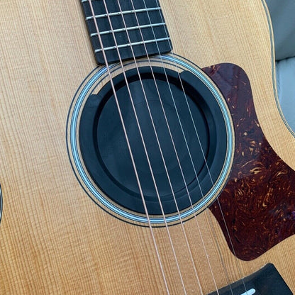 A Feedback Buster / Suppressor fitted to a small acoustic guitar in a lounge.