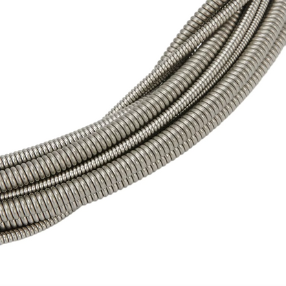 Close-up of four round wound Bass Guitar Strings on a white background.