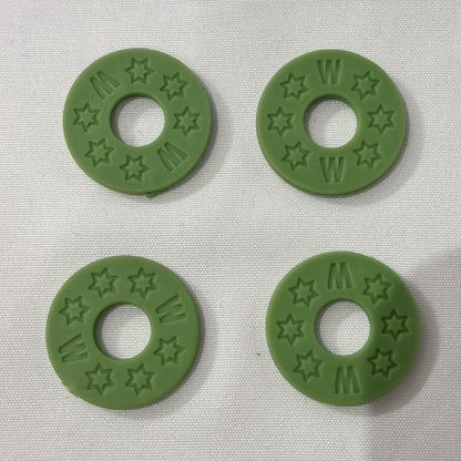 Four Green Rubber Guitar Strap Locks on a light grey background.