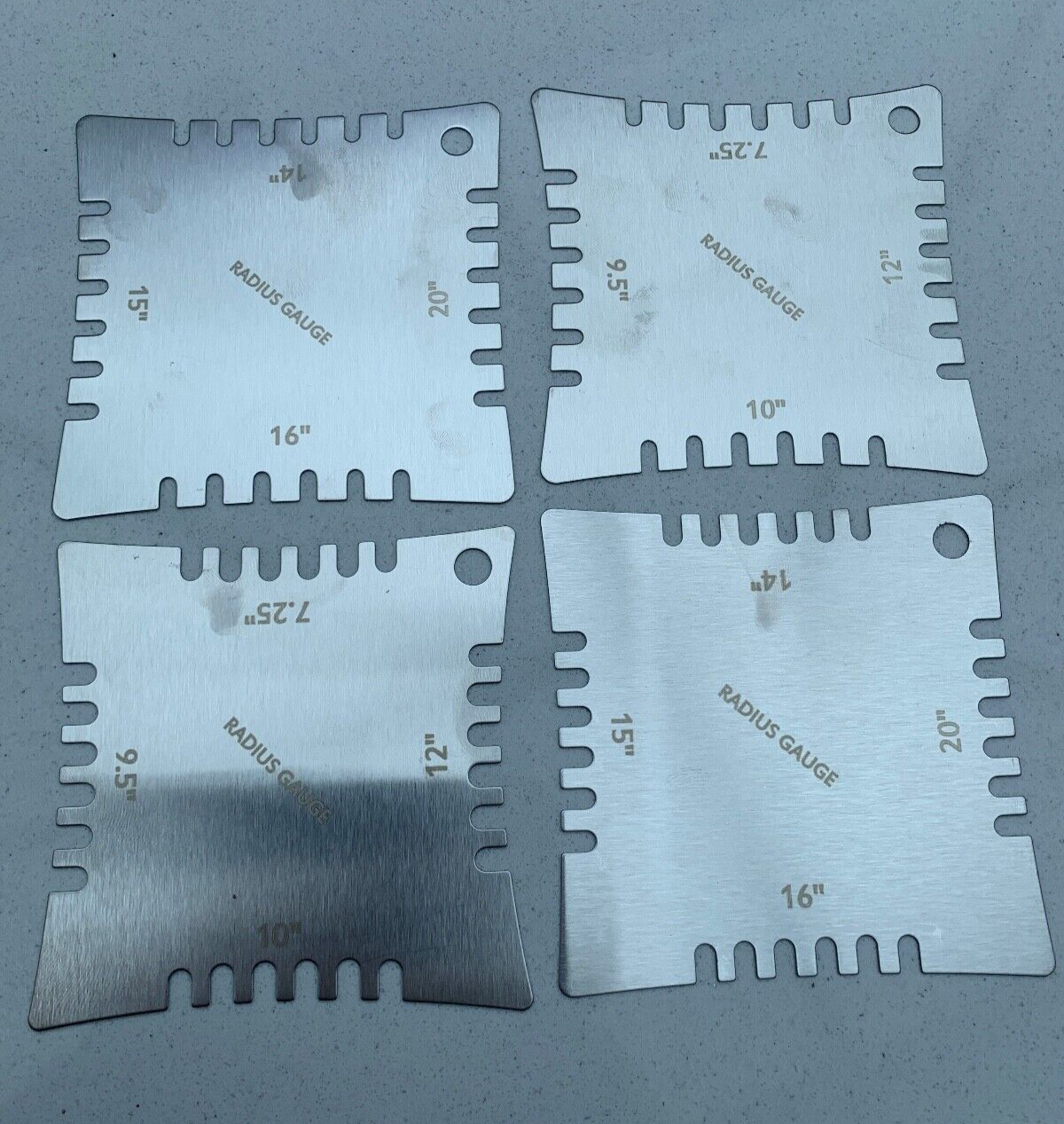 The rear of Four Guitar Notched Radius Gauges photographed on a  grey background