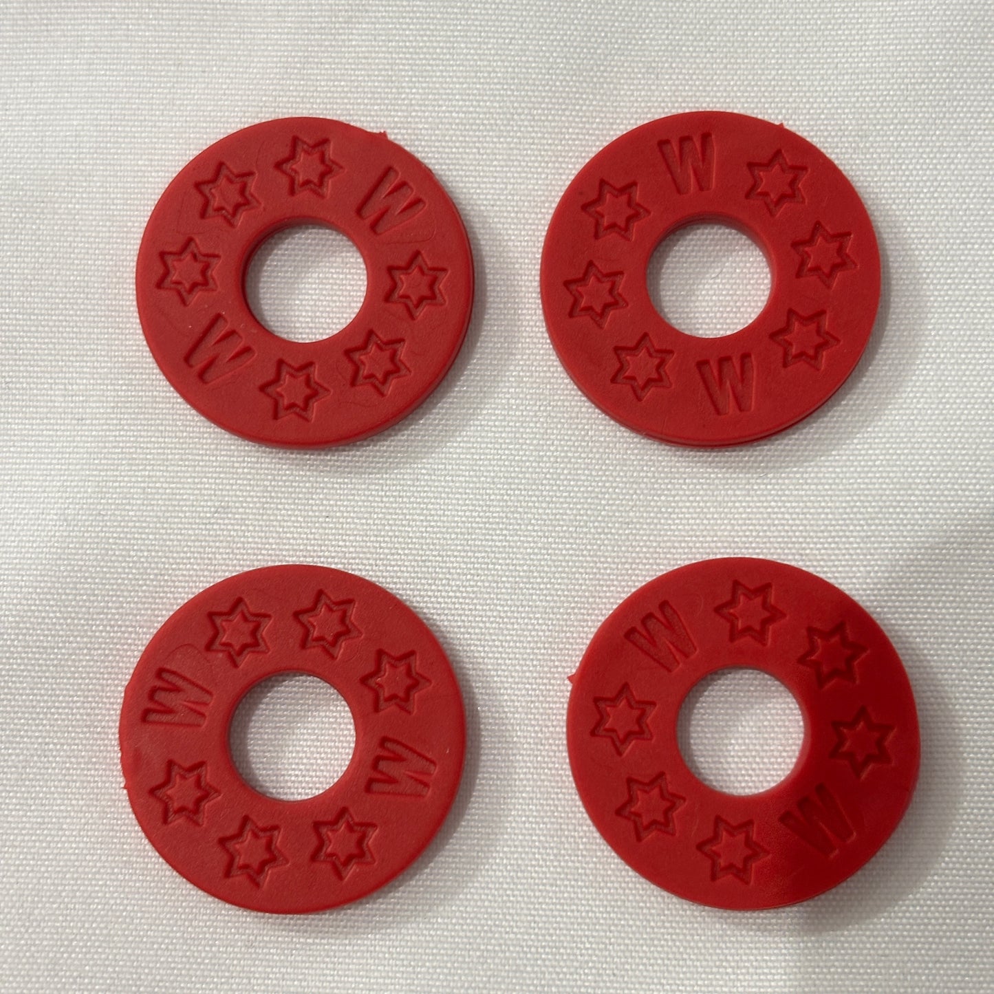 Four Red Rubber Guitar Strap Locks on a light grey background.