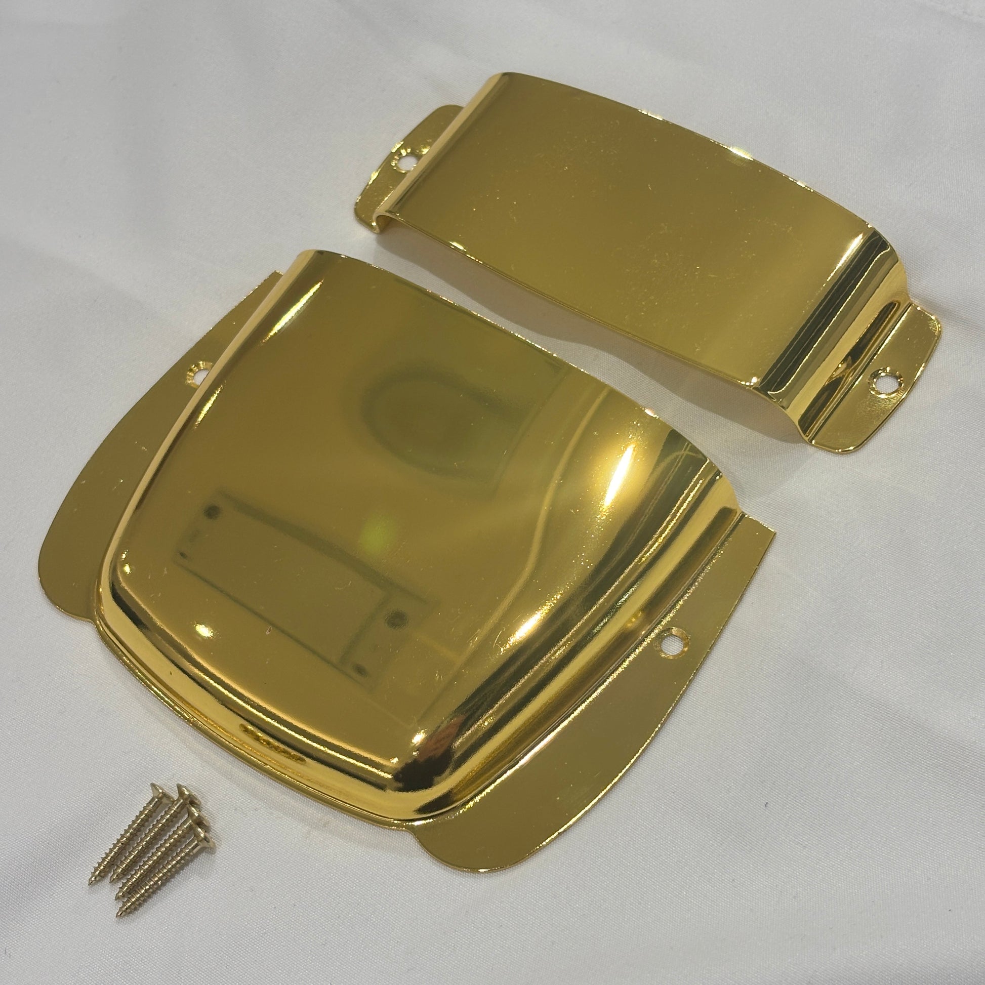 Gold Bass Guitar Bridge and Pickup Covers photographed from the side on a White background.