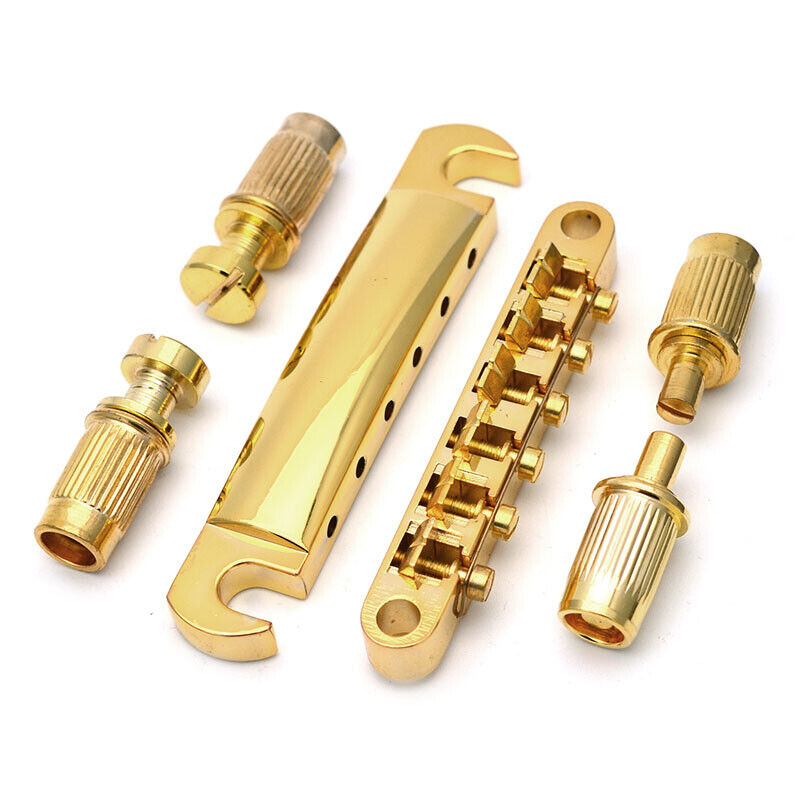 Electric Guitar bridge kit in gold LP-style against a white background.