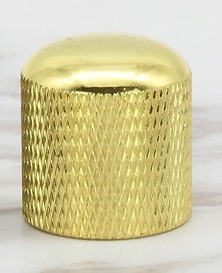Gold electric guitar control knob on a white background.