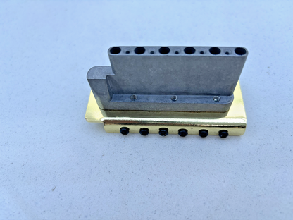 Gold Tremolo Bridge block (underside) on a grey background.