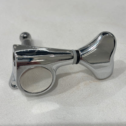 Chrome Fish Tail Button Guitar Tuner on  textured fabric background.