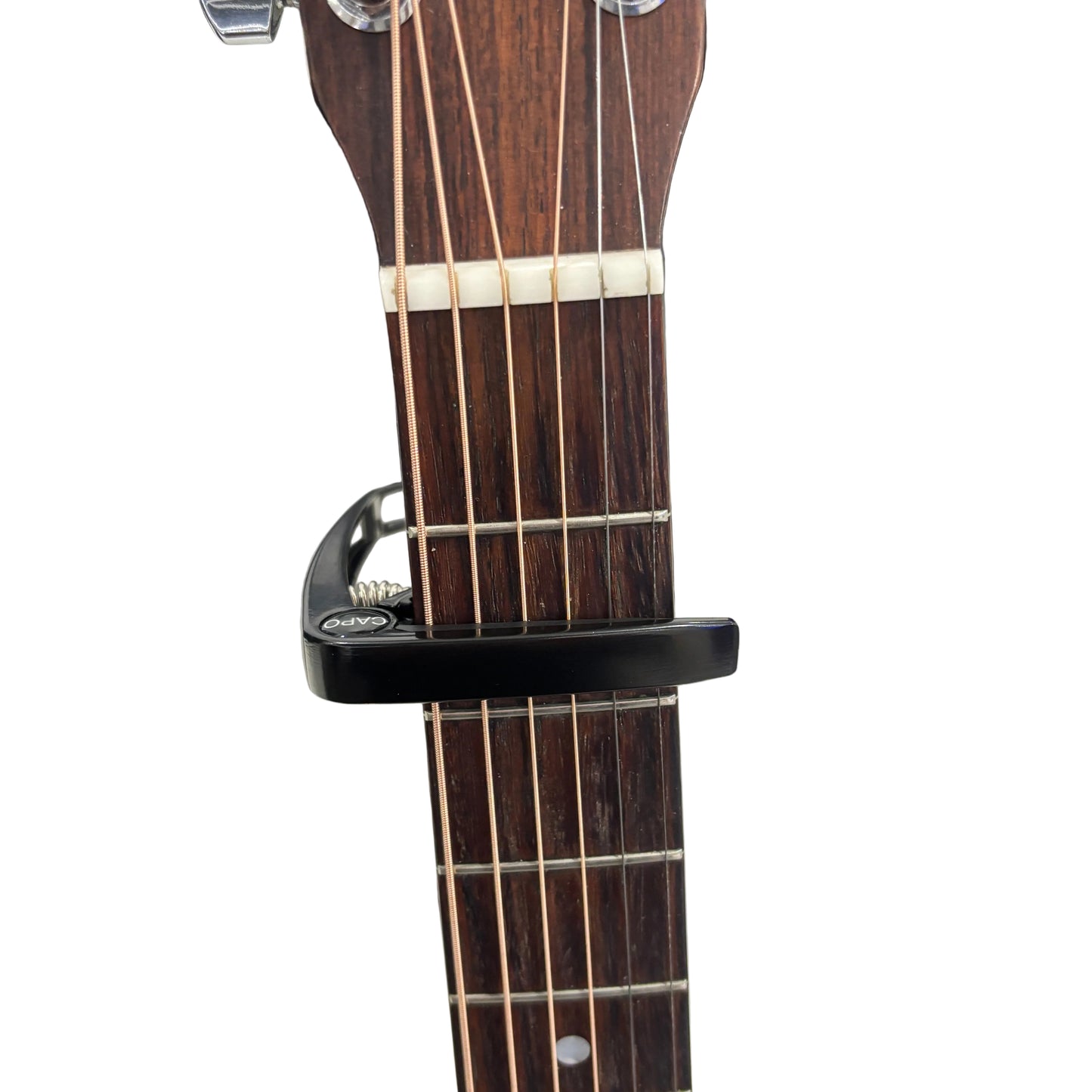 Guitar capo on a guitar neck with a white background.