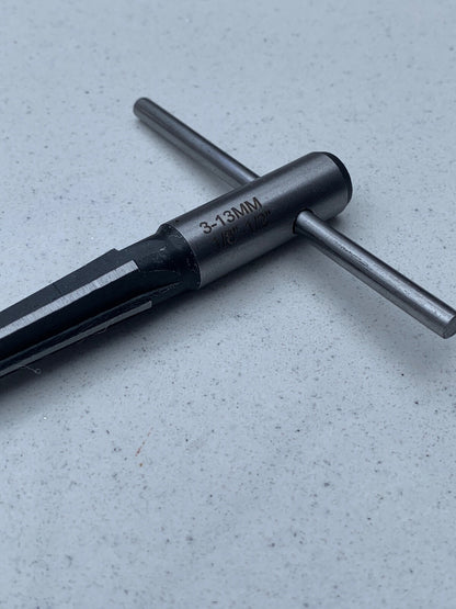 Close up of a Guitar Hole Reamer from the side against a grey background.