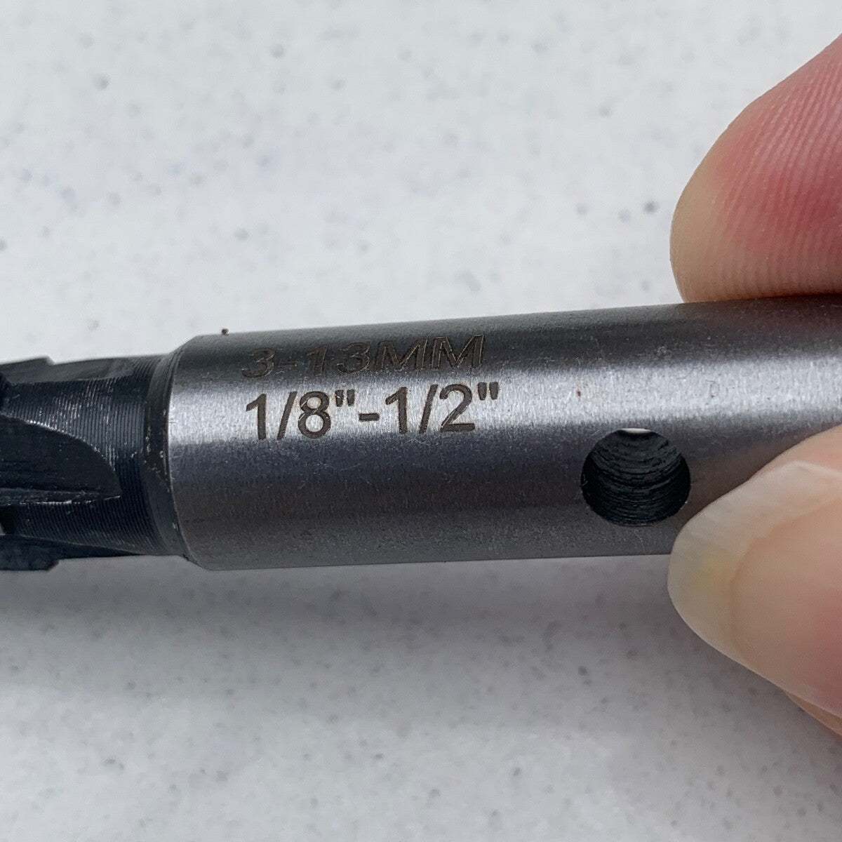 Close up of the imperial size of a Guitar Hole Reamer against a grey background.
