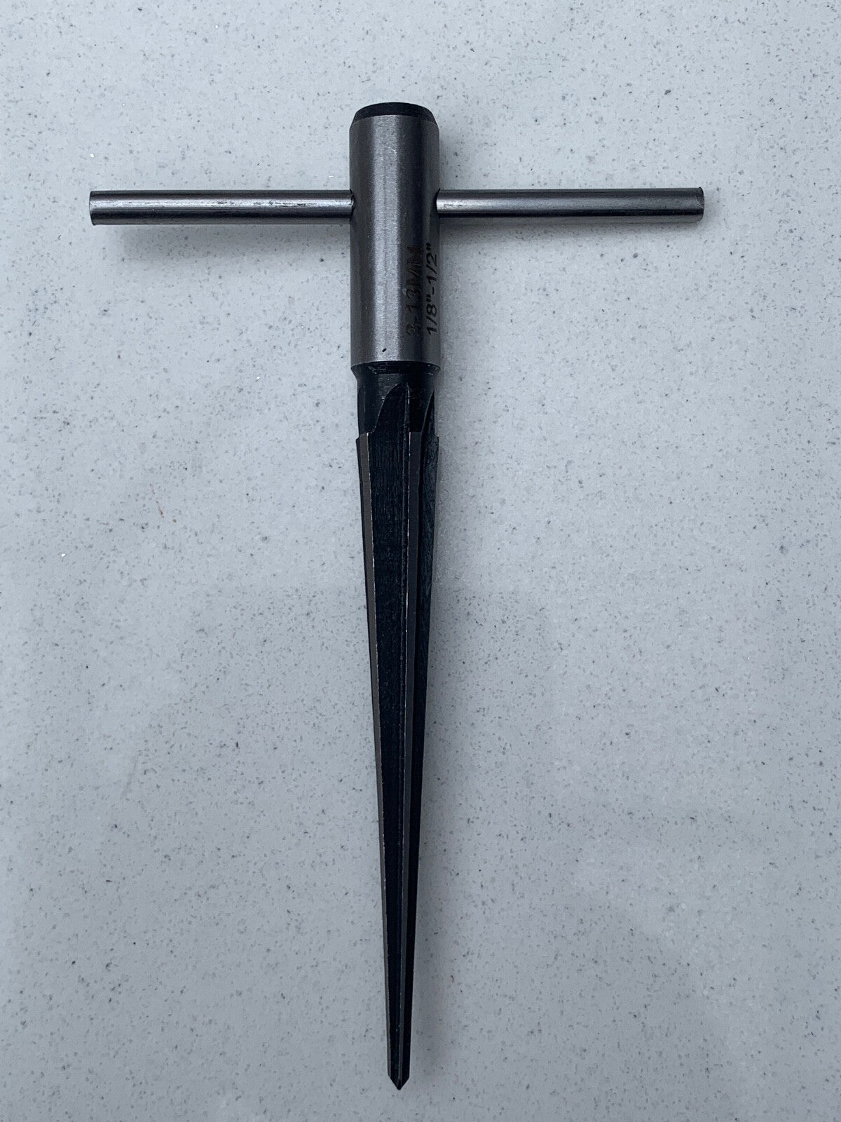 Guitar Hole Reamer against a grey background.