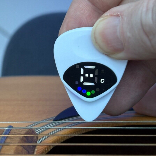 A Guitar Pick Tuner photographed in use on an acoustic guitar.