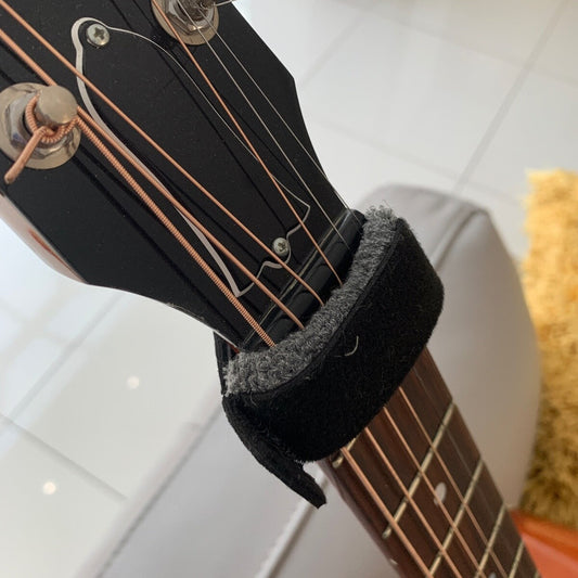 Close-up of a Guitar String Muter/Damper photographed on a guitar neck.
