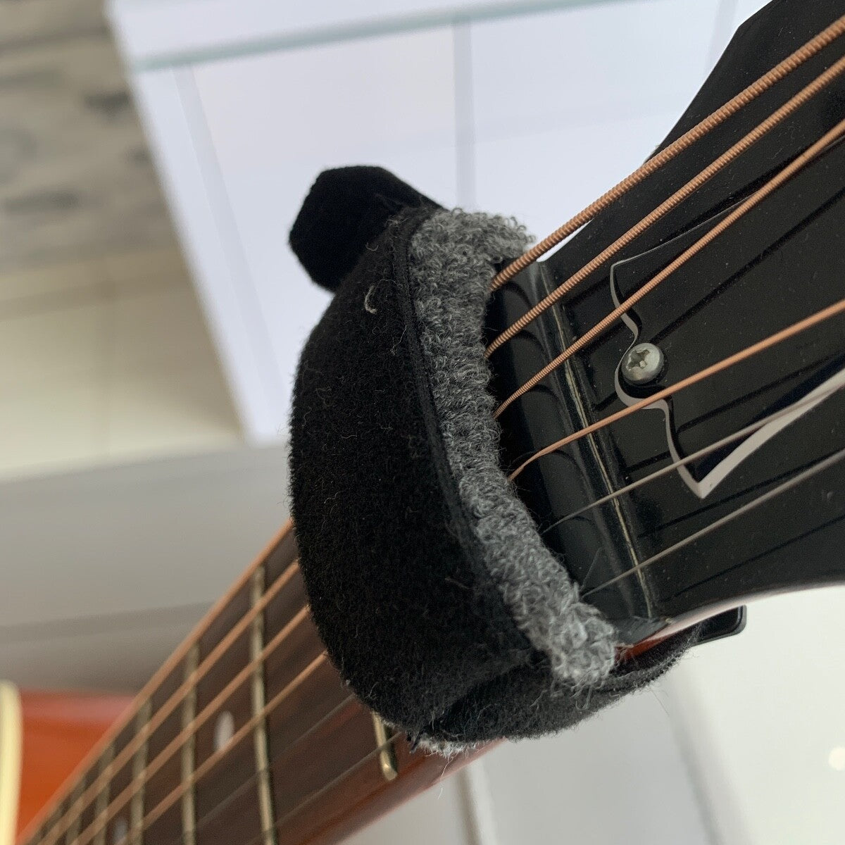 Close-up of a Guitar String Muter/Damper photographed on a guitar neck from above.