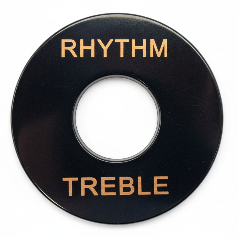 Close-up of a Guitar Toggle Switch /Pick Up Selector Surround Plate in black with gold text on a grey background.