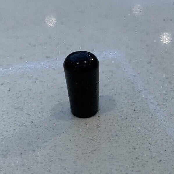 Black metal electric guitar Toggle Switch Tip on a grey background.