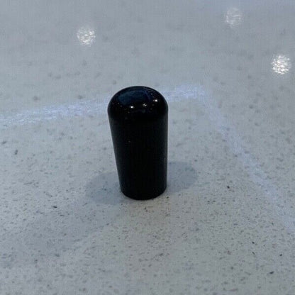 Black metal electric guitar Toggle Switch Tip on a grey background.