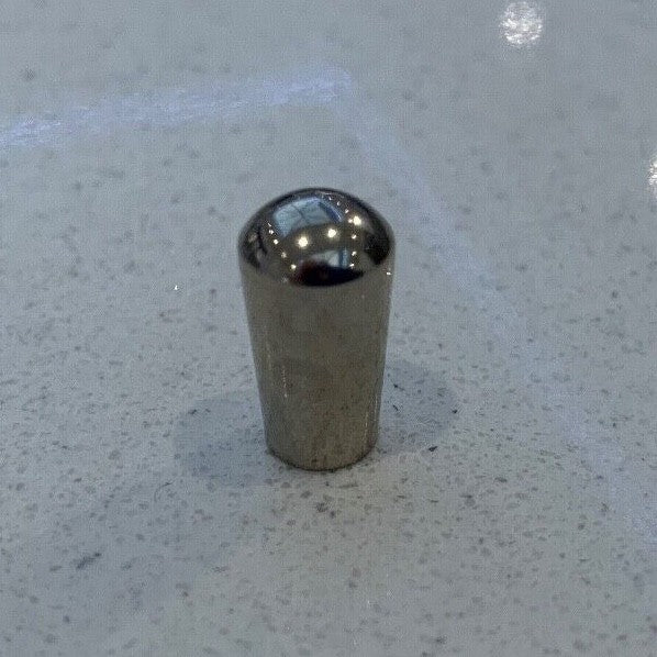 Chrome metal electric guitar Toggle Switch Tip on a grey background.