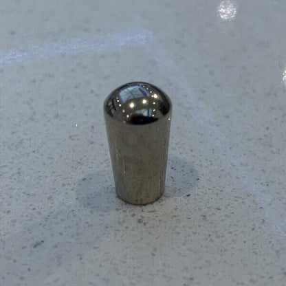 Chrome metal electric guitar Toggle Switch Tip on a grey background.
