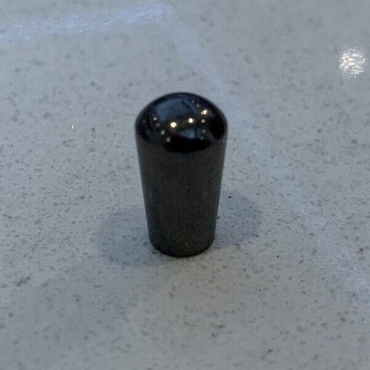 Nickel metal electric guitar Toggle Switch Tip on a grey background.