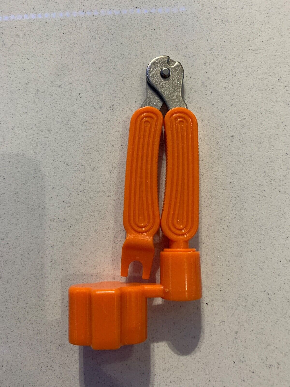 Orange Guitar Multi Tool against a light grey background.