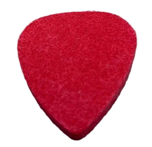 Red felt guitar pick ('plectrum') on a grey surface.