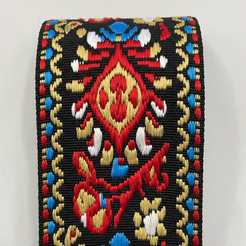 Close up of a Red, Gold and Black Embroidered Guitar Strap pattern on a white background.